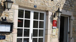 Un edificio de piedra con un letrero que dice "hotel la Poularde".