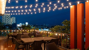 An outdoor dining area with string lights, tables, and chairs. - MySpace Hotel at BGC (Taguig)