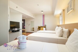 A hotel room with two beds, a TV, a desk, and a chair. - MySpace Hotel at BGC (Taguig)