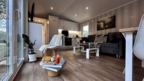 Un salon moderne avec un canapé, une table basse et une vue sur la cuisine.