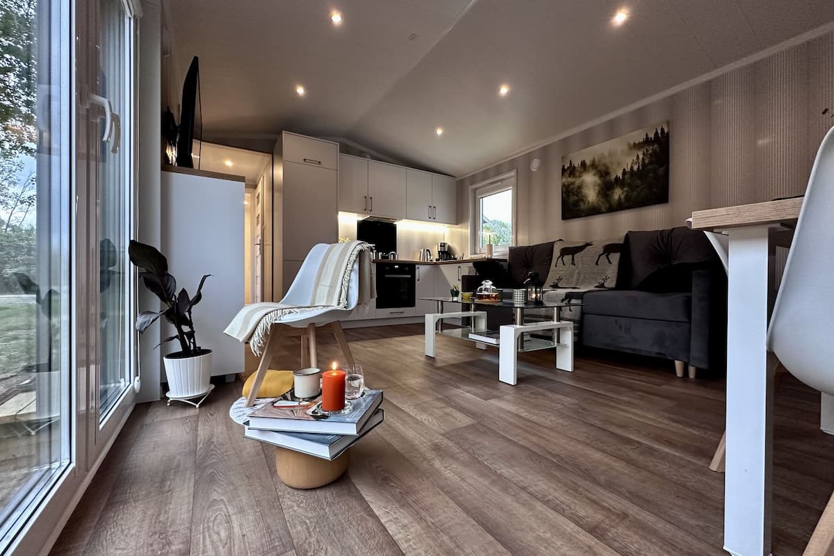 Una sala moderna con sofá, una mesa de centro y vista a la cocina.