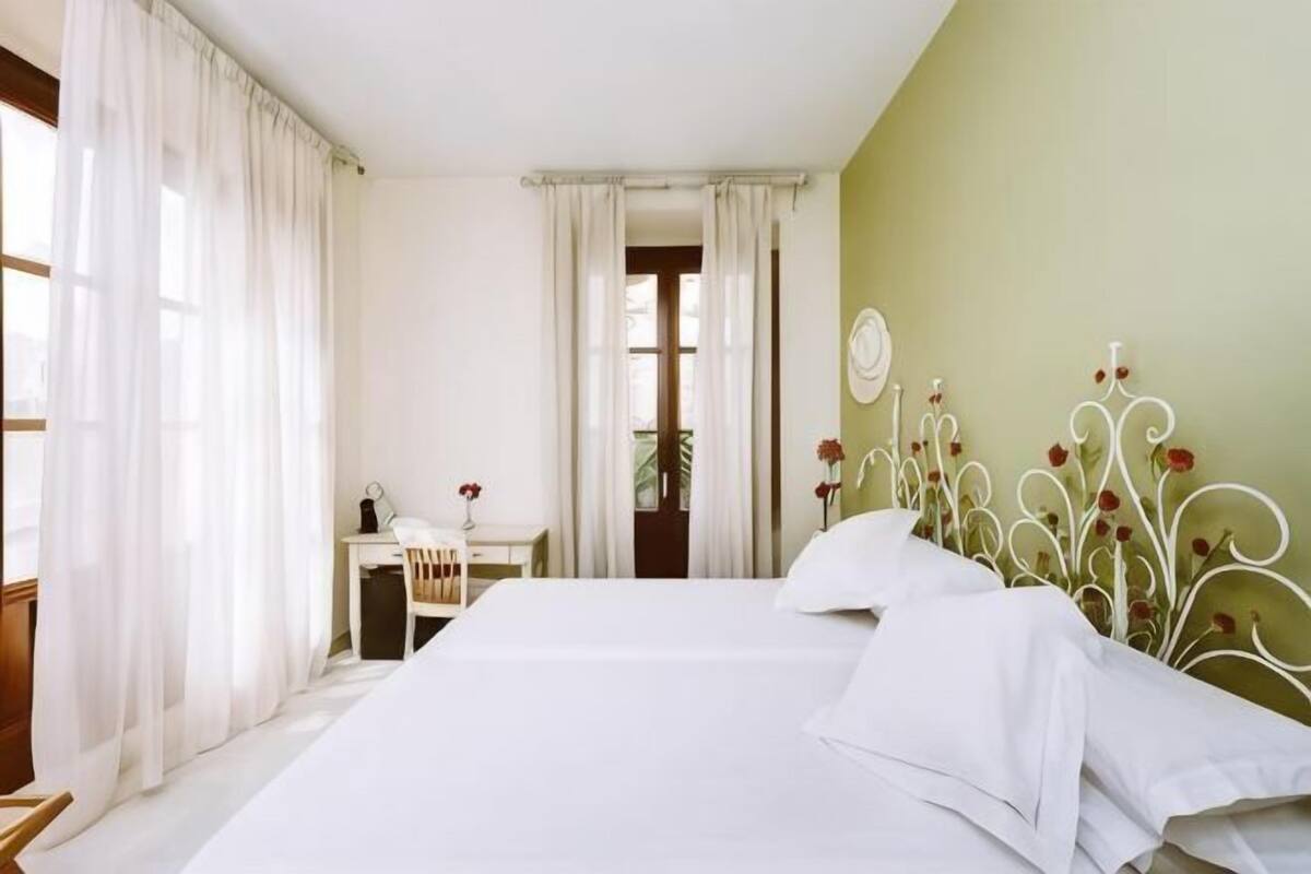 A bedroom with a bed, a desk, and a chair.