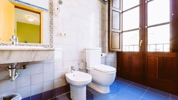 A bathroom with two toilets, a sink, and a mirror.