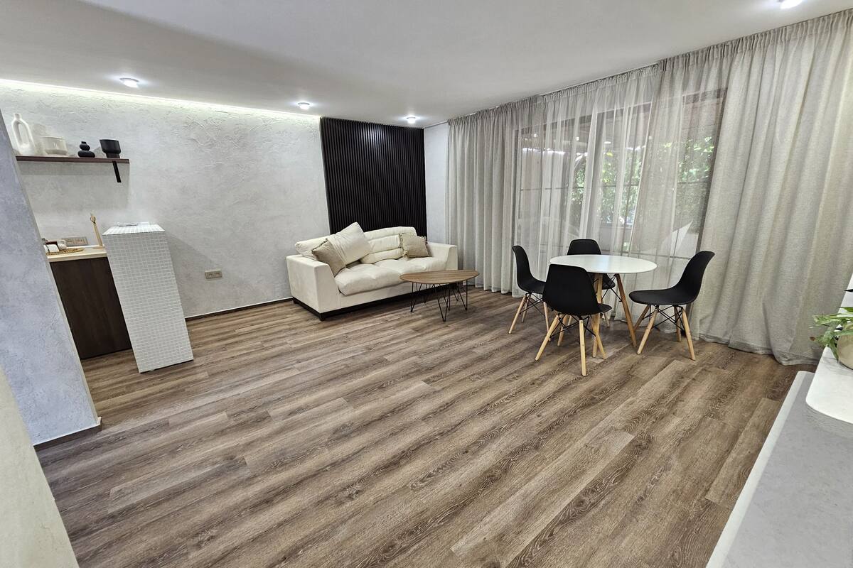 Un salon moderne avec un canapé, une table à manger et des chaises.