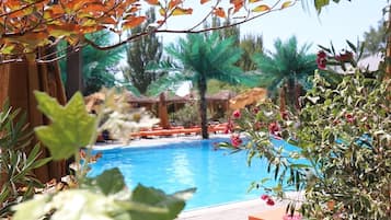 Una piscina techada, una piscina al aire libre de temporada, sombrillas