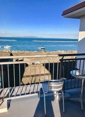 A balcony with a view of the sea, a chair, and a table. - Minshuku Kaikeibo (Hannan)