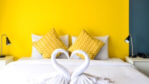 A hotel room with a bed, two nightstands, a lamp, a phone, and a swan-shaped towel arrangement. - Two Color Patong (Patong)