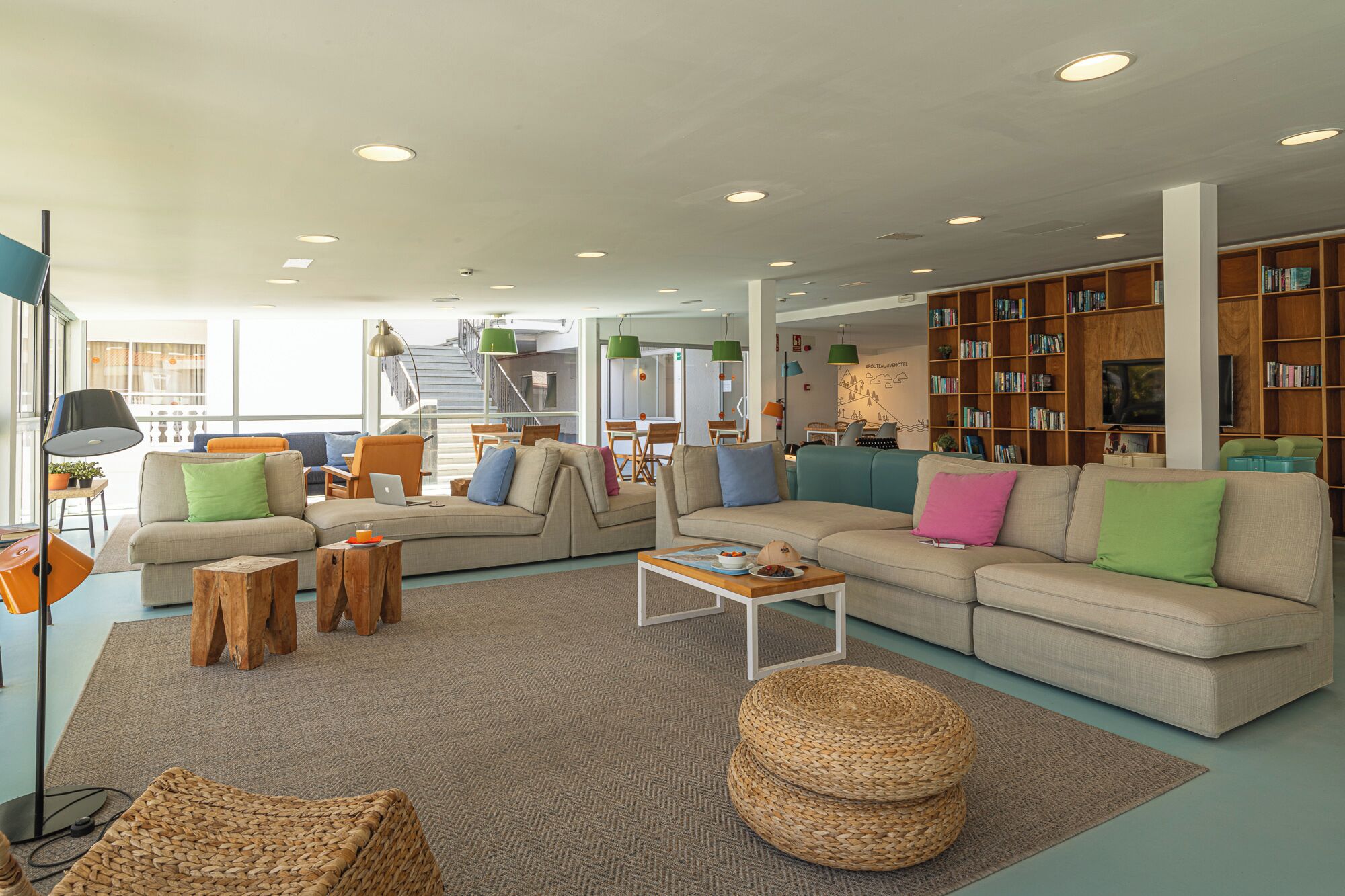 A spacious living area with multiple sofas, a coffee table, and a bookshelf filled with books.