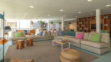 A spacious living area with multiple sofas, a coffee table, and a bookshelf filled with books.