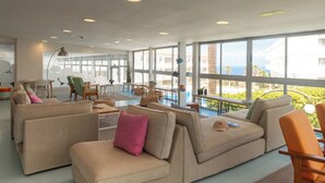 A spacious living area with large windows, a pool, and a view of the ocean. - Route Active Hotel (Los Realejos)