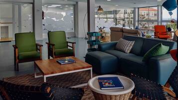 A modern living room with a blue sofa, green armchairs, and a wooden coffee table.
