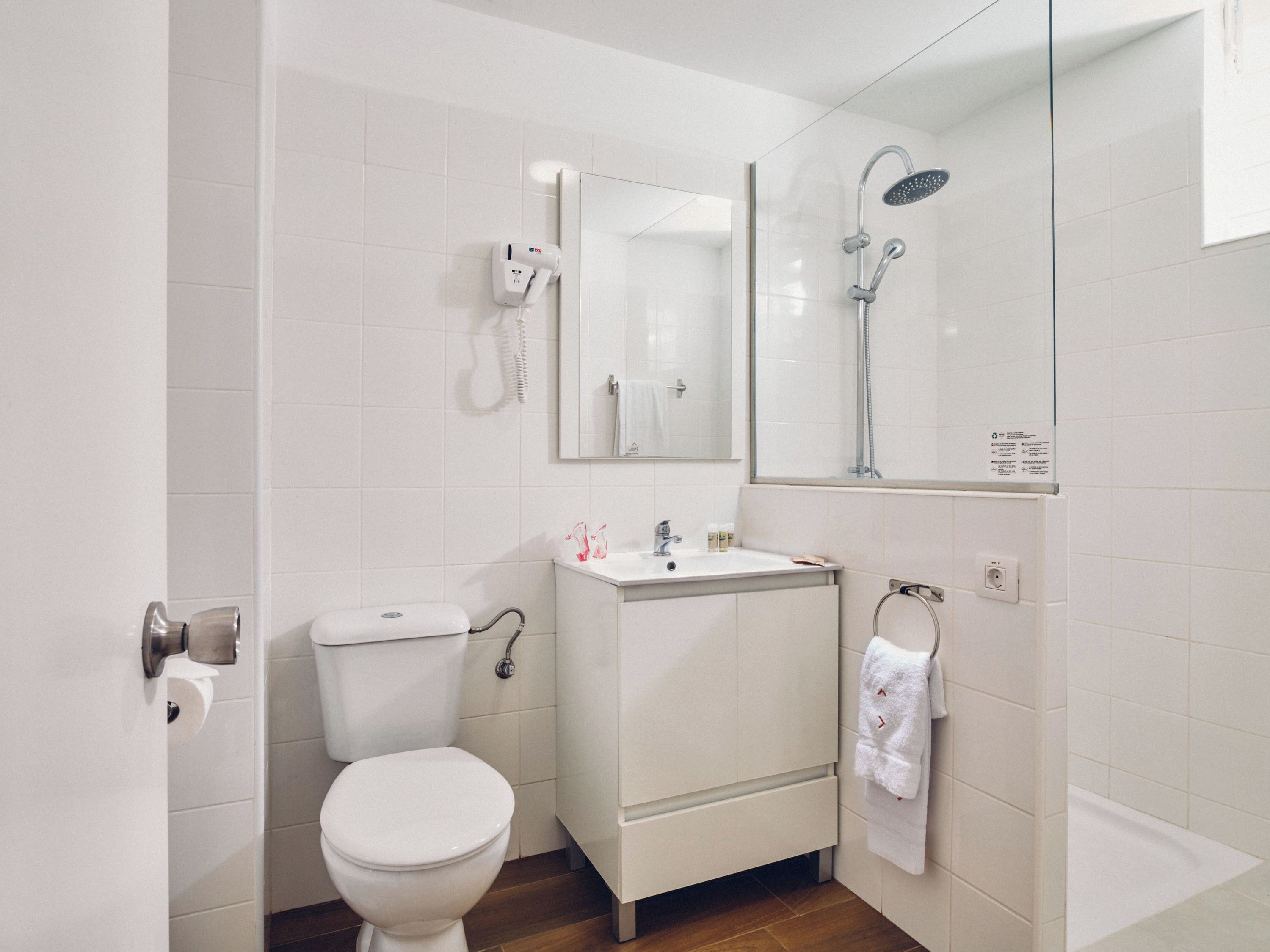 Ein modernes Badezimmer mit Toilette, Waschbecken und Dusche.