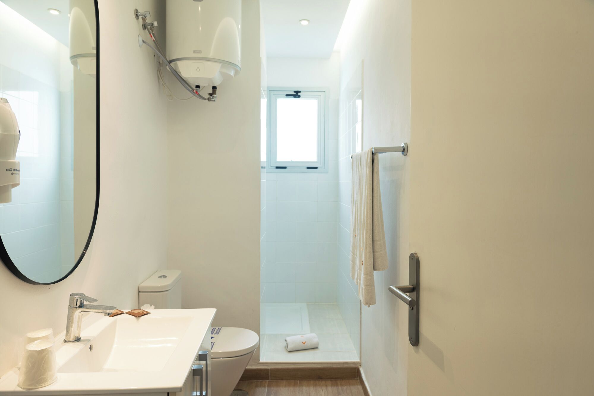A modern bathroom with a white sink, toilet, and shower.