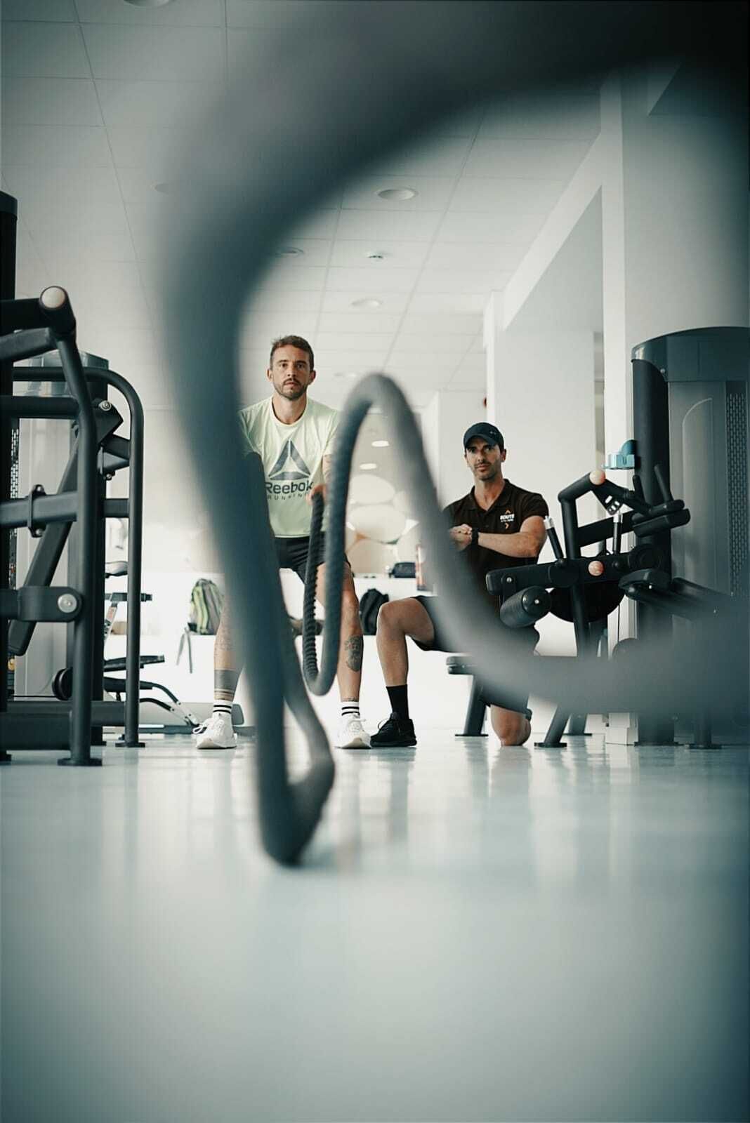 A gym with exercise equipment, including a squat rack and a bench.