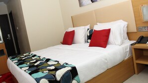 A hotel room with a bed, a bedside table with a phone, and a door. - Avital Suites And Resort (Lagos)