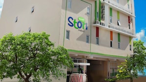 A multi-story hotel with balconies, a sign reading "Hotel Stori," and a clear blue sky. - Stori Hotel Ambon (Ambon)