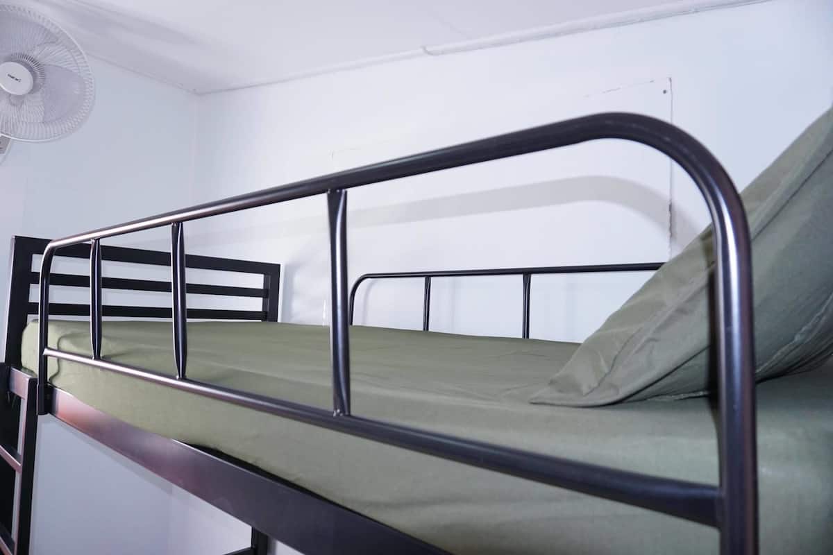A bunk bed with a metal frame and green bedding.