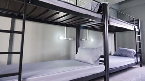 A bunk bed room with two beds, each with a pillow and a mattress. There are two wall-mounted light fixtures above each bed. - Culture Club Backpackers - Hostel (Ko Pha-ngan)