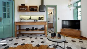 Una cocina moderna con armarios de madera, estufa integrada y una zona de comedor con alfombra estampada.