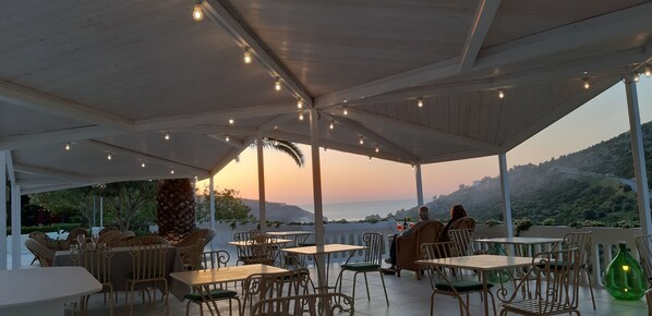 An outdoor seating area with tables and chairs, overlooking a scenic landscape. - La Locanda della Castellana (Peschici)