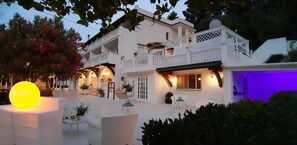 A white building with balconies and outdoor seating. - La Locanda della Castellana (Peschici)