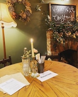 Una mesa de comedor con una vela, un menú y un cartel que dice 'Reservado'.