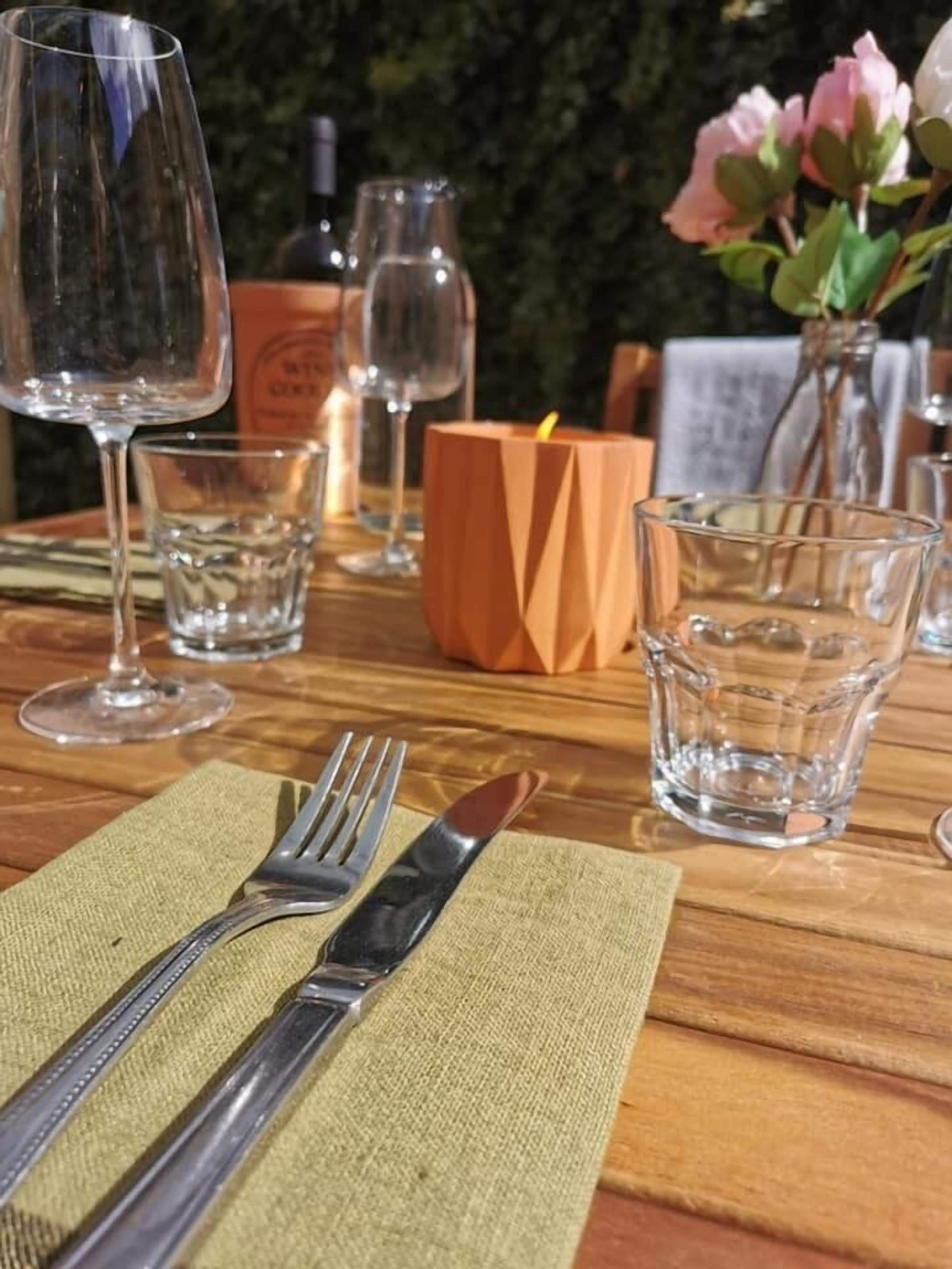 Une table à manger dressée avec un couteau, une fourchette et de la verrerie, notamment un verre à vin et un verre à eau.