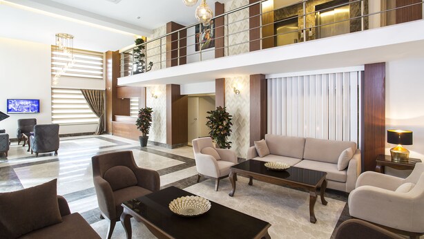 A spacious lobby with a high ceiling, a mezzanine level, and a modern chandelier. - Perla Arya Hotel (Izmir)