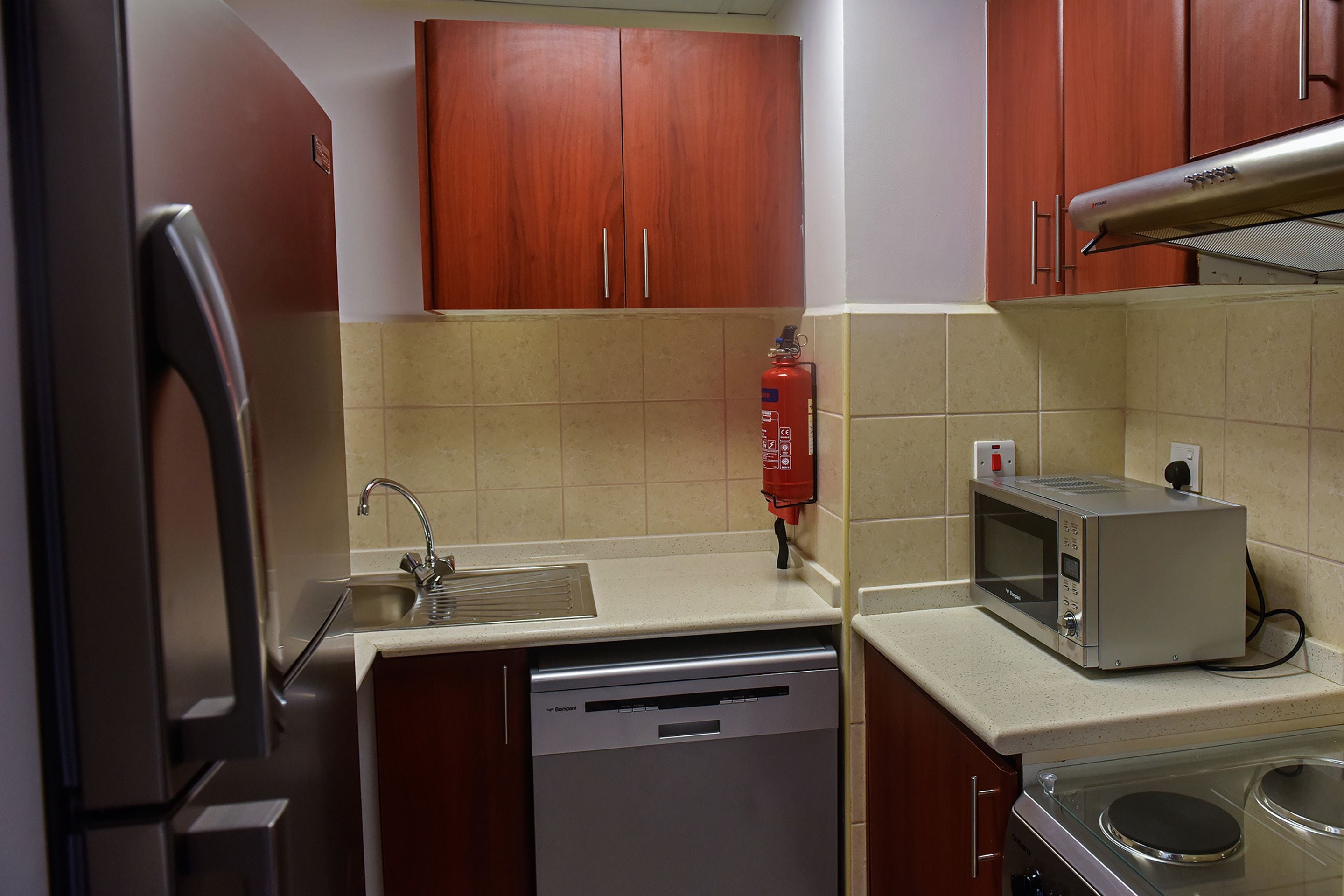 A compact kitchen with a dishwasher, a microwave, and a stove.