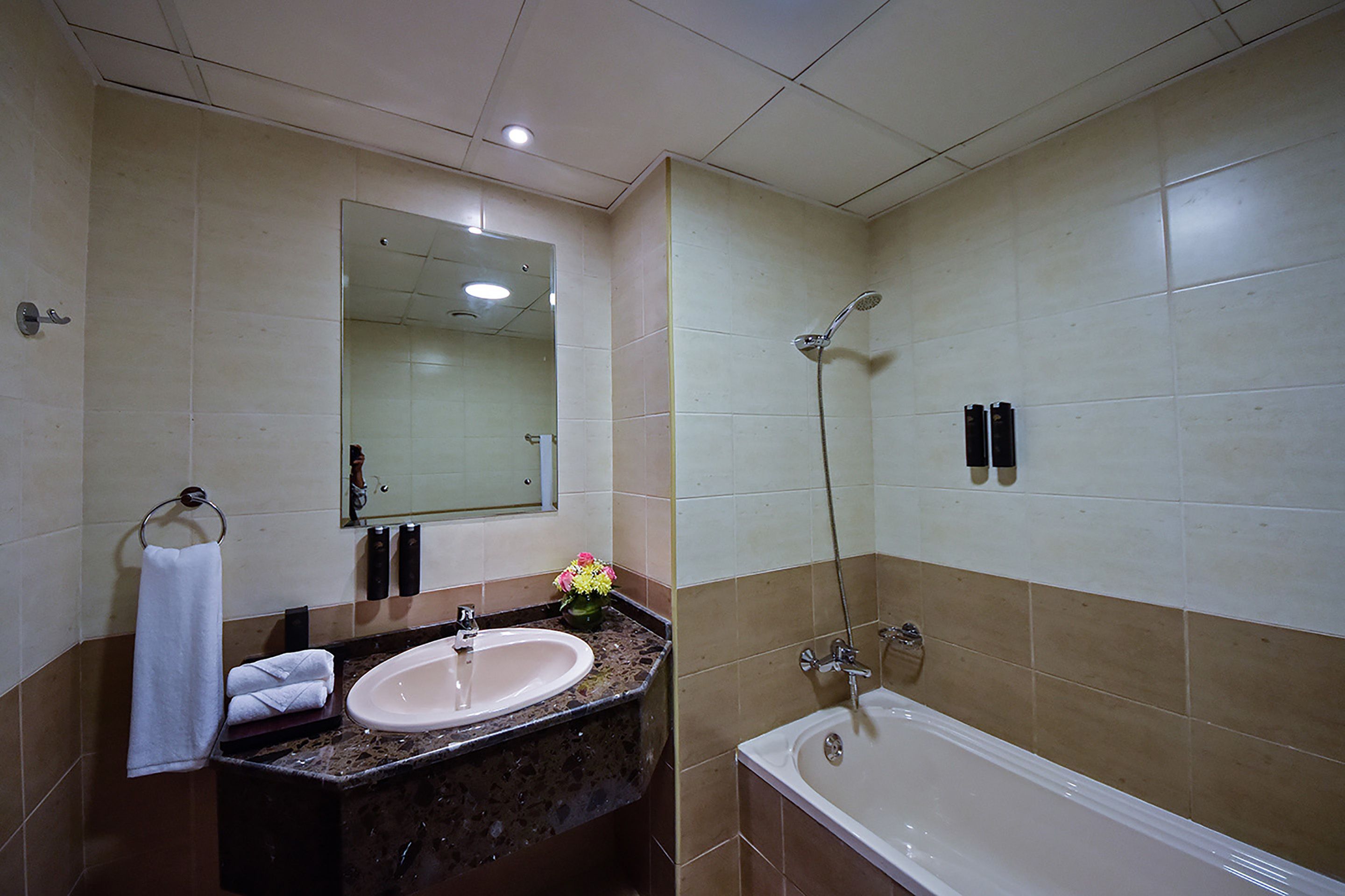 A bathroom with a sink, mirror, and bathtub.