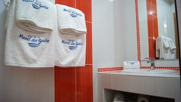 A bathroom with two white towels hanging on a rack, a sink, and a mirror.