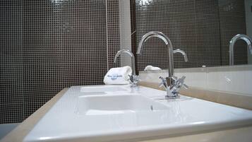 Un baño con dos lavamanos, un espejo y un dispensador de toallas.