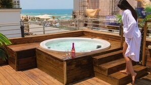 A wooden deck with a hot tub, a bottle of champagne, and glasses. - Dream Beach TLV Boutique Hotel (Tel Aviv)