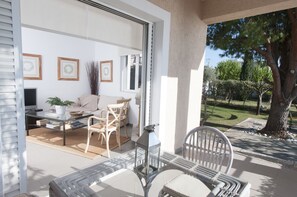 An open-plan living area with a sofa, chairs, a coffee table, and a TV. - Messinian Blue SeaSide Villa (Kalamata)