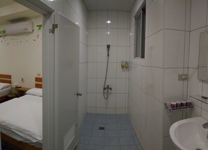 Cozy retreat with a single bed, shower area, and modern amenities.