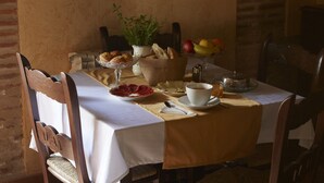 A dining table set with bread, fruit, and a cup of coffee. - Posada La Casa de Las Manuelas (Horcajo de las Torres)