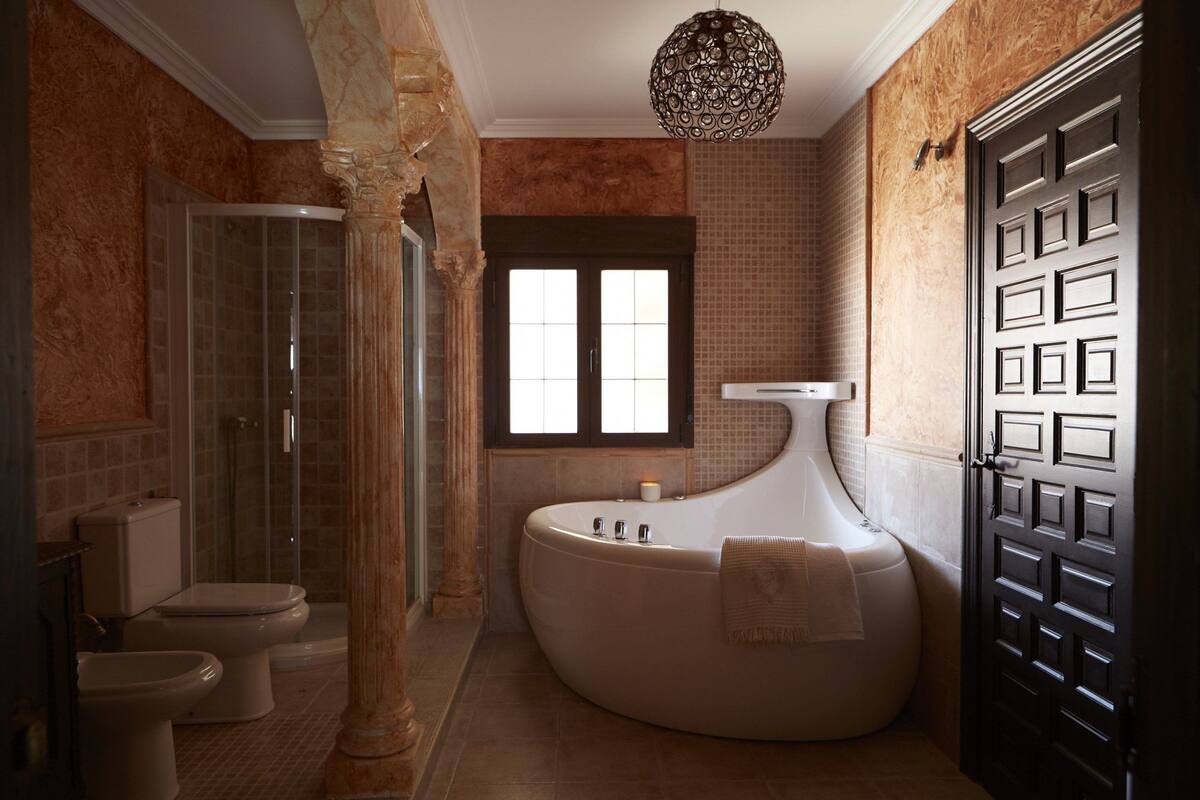 Ein Badezimmer mit einer freistehenden Badewanne, einer Duschkabine aus Glas und einem großen Spiegel.