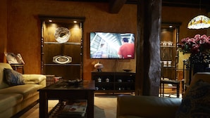 A cozy living room with a television, a coffee table, and a sofa. - Posada La Casa de Las Manuelas (Horcajo de las Torres)