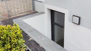 A modern building with a metal railing, a door, and a small window. - Feldhouse (Bremen)