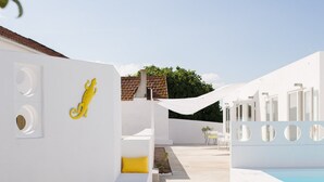 A modern outdoor area with a pool, white walls, and a yellow decorative element. - Casasupertubos (Peniche)