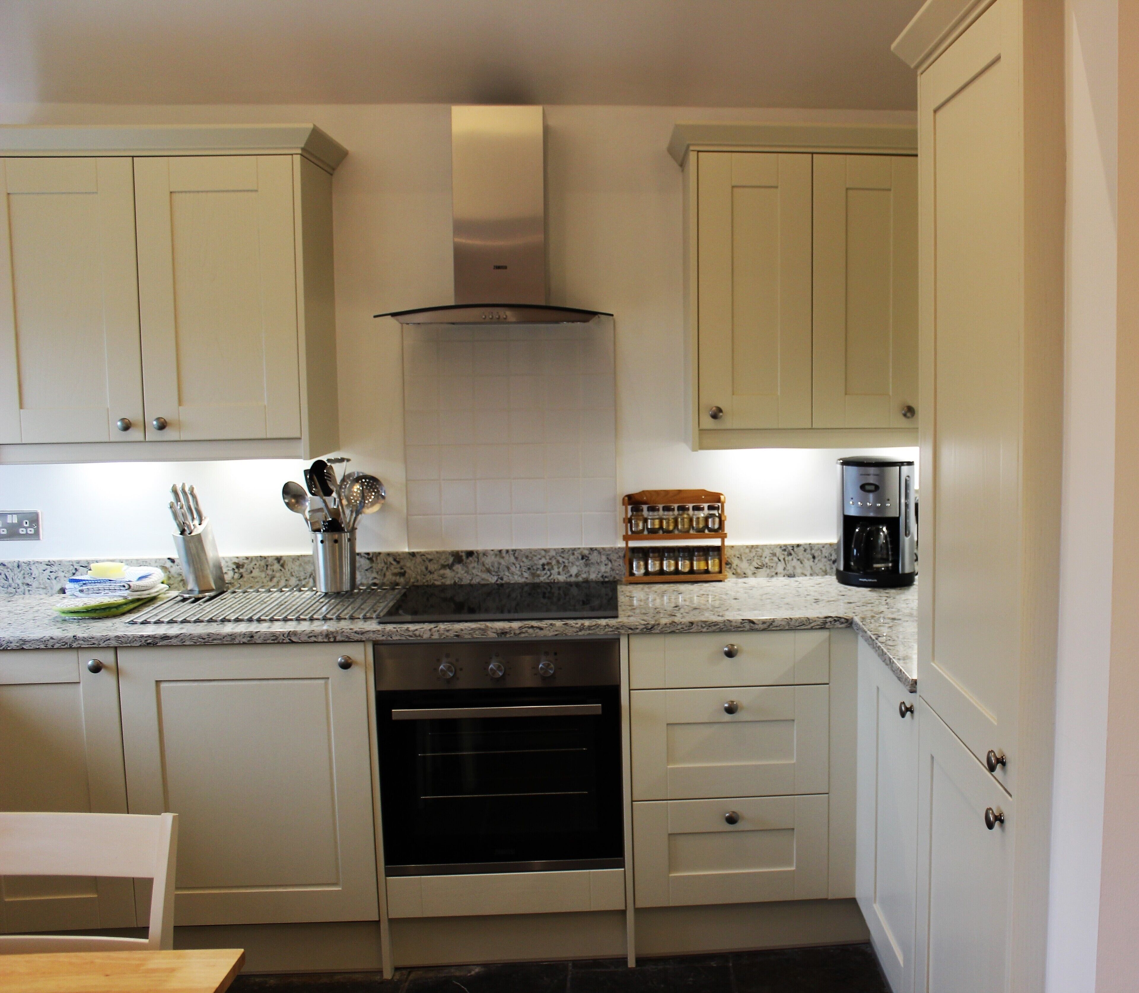 A compact kitchen with a stove, oven, and coffee maker.