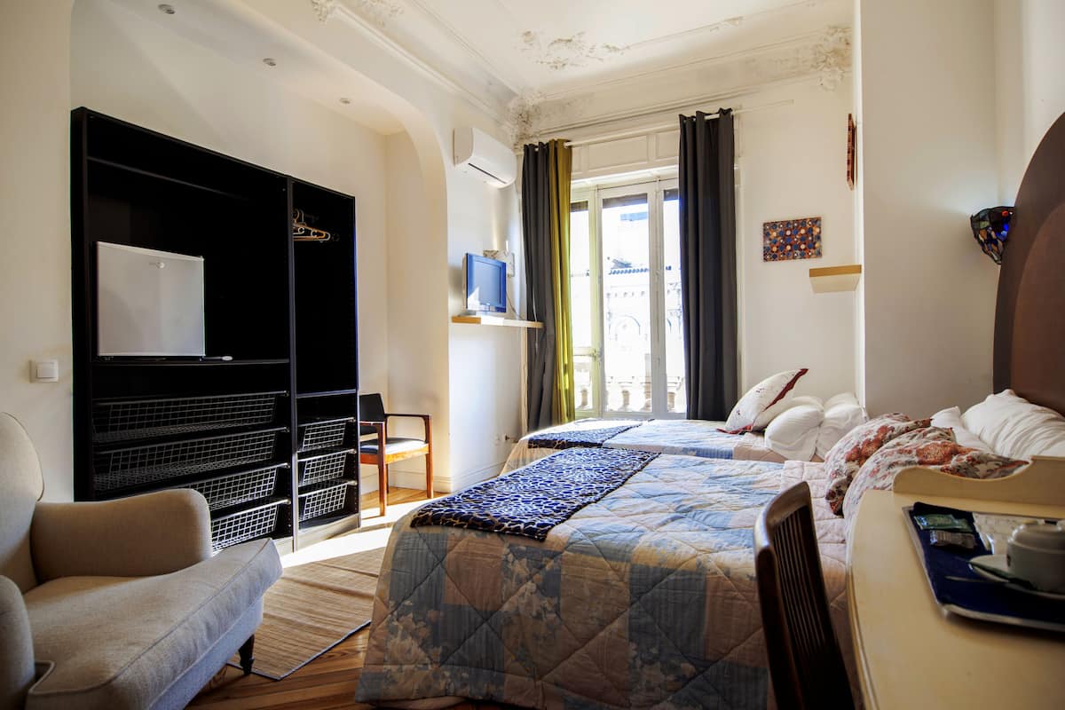 Une chambre d’hôtel comprenant un lit, une chaise, un bureau, une armoire et un téléviseur.
