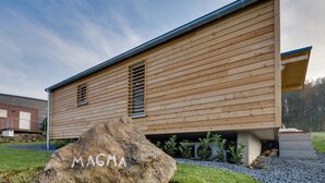 Un edificio moderno de madera con revestimiento horizontal y techo inclinado.