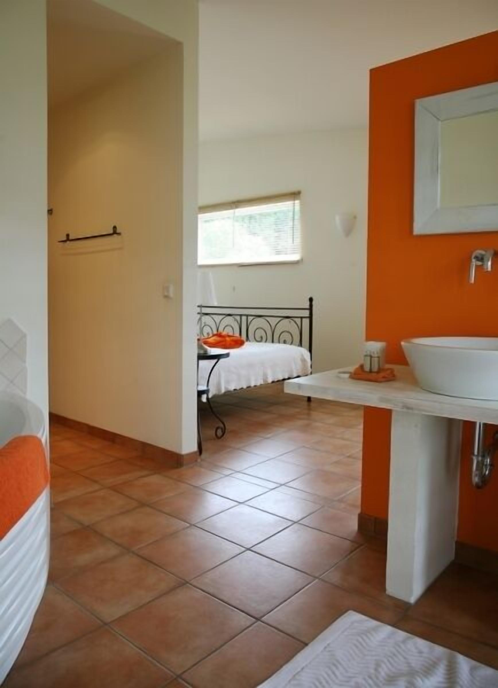 Un baño con cama, lavamanos y ventana.