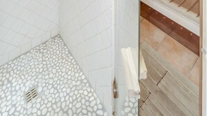 A shower area with a glass door, a showerhead, and a tiled floor. - EIFELTRAUM Mediterrana - pure silence (Berlingen)