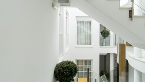 A modern interior with a staircase, a potted plant, and a sign that reads "SUITES". - Suites del Pintor Historial Center, by Hoteles con Cultura (Málaga)
