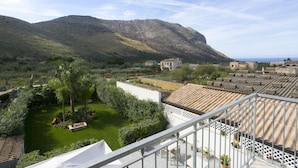Una terraza con vistas a un paisaje montañoso y un jardín.