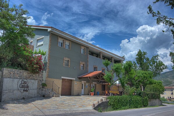 A two-story building with a stone facade, a tiled roof, and a sign indicating it is a restaurant. - Hotel Casa Custodio (Isabena)