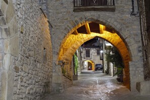 A stone archway leading to a building with a wooden ceiling.