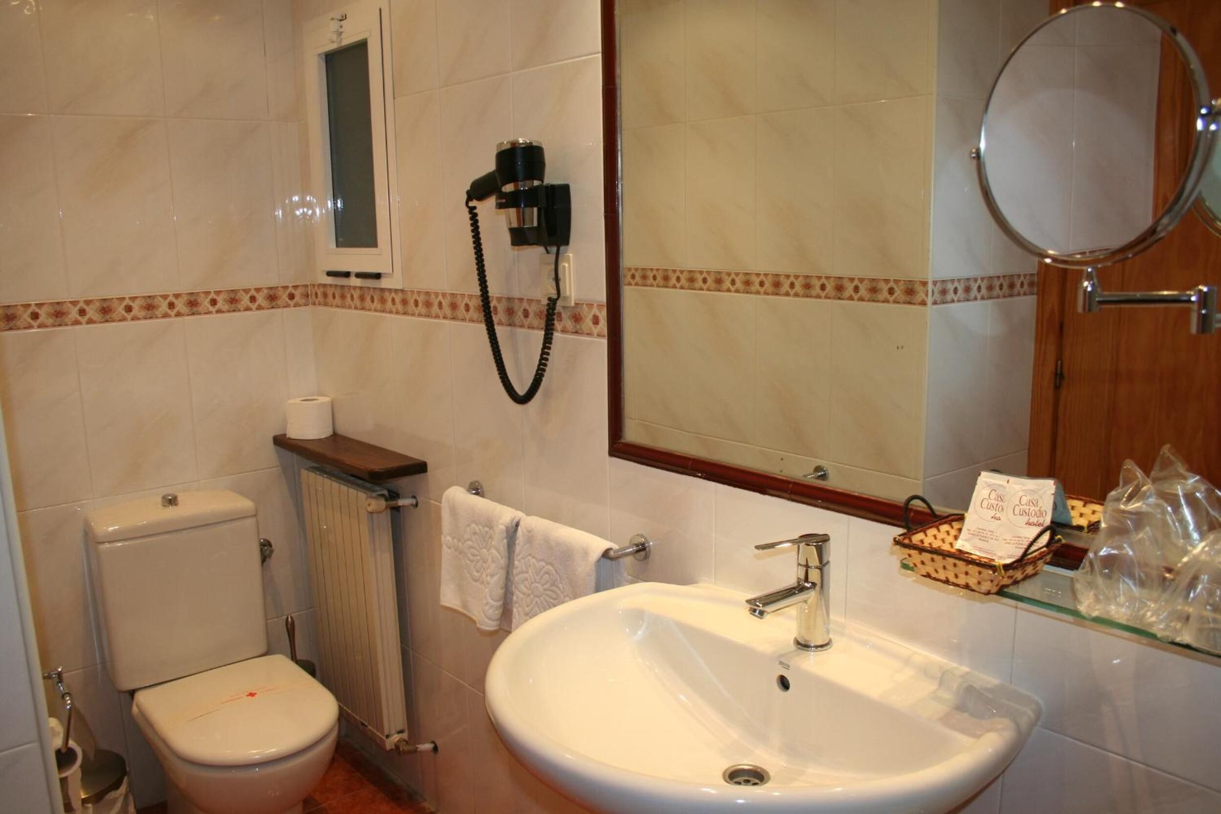 Une salle de bain comprenant des toilettes, un lavabo, un porte-serviettes et un miroir.